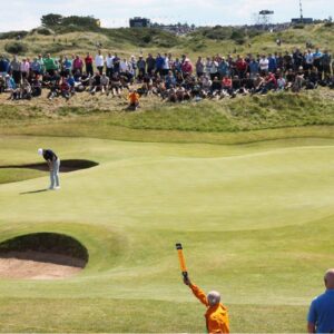 golfer surrounded by crowd on green course