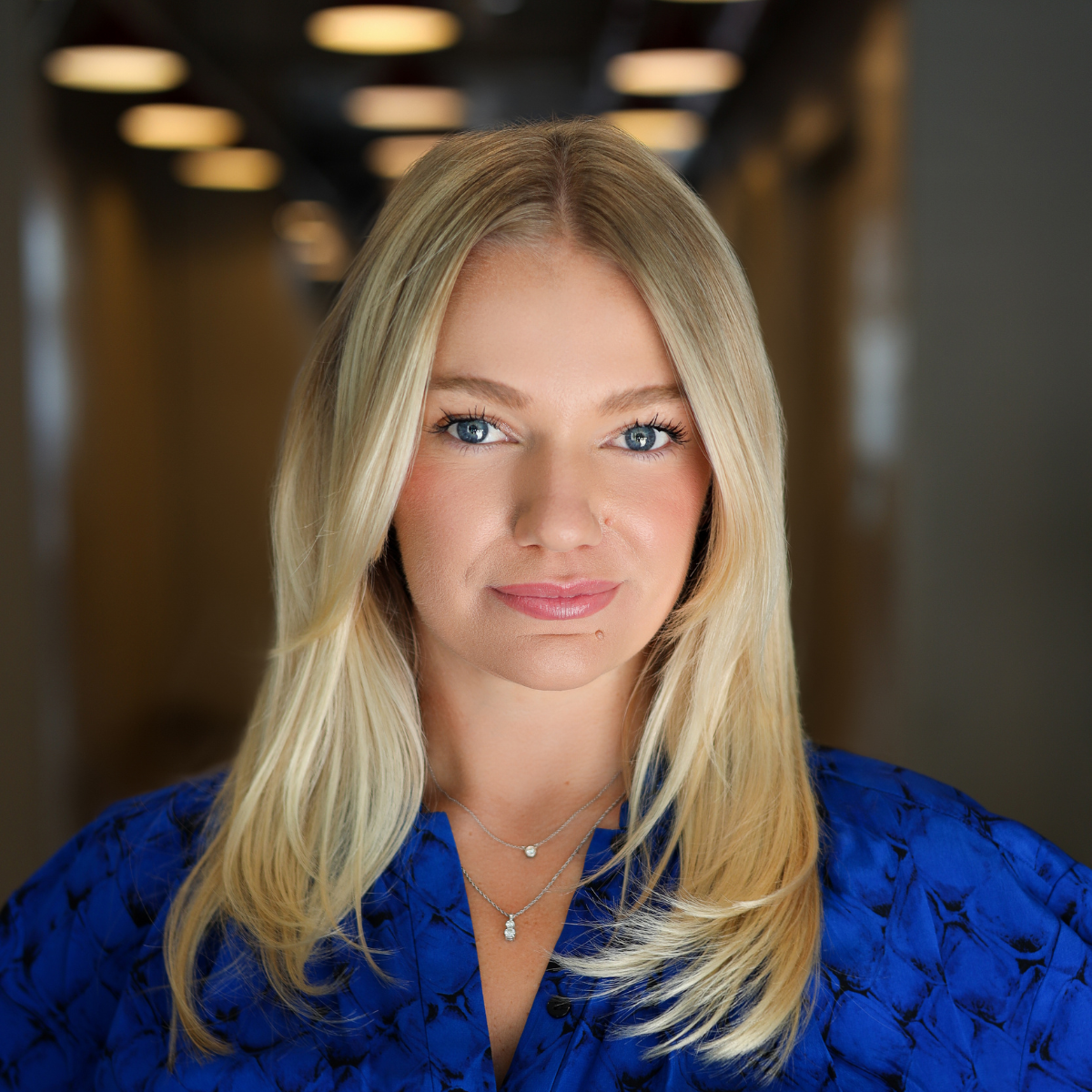 headshot of blonde woman with blue shirt